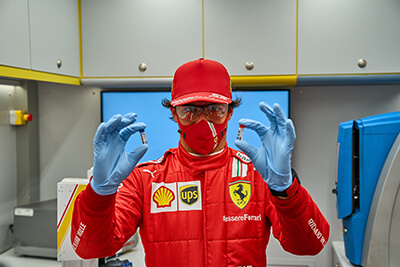 Race car driver holding a bottle of Shell Helix Ultra, which contains carbon-neutral lubricants